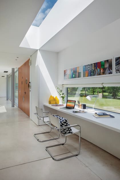 Lámpara de mesa 'Cuerno' con pantalla de cerámica esmaltada (Iluminación Agüero) y sillas cantilever cromadas de Gowa's.