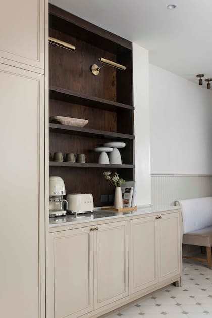Lámparas amuradas y tiradores en bronce cepillado, una opción de elegancia discreta en esta cocina de Recoleta diseñada por Estudio Método.