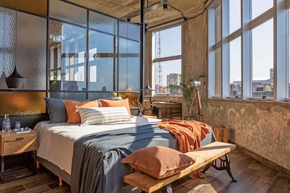 Mesas de luz, cómoda y perchero con ruedas (Modulouno). Ropa de cama, almohadas, almohadones, manta y pie (todo, Lote Propio). Banco de madera (Familia Echaide).