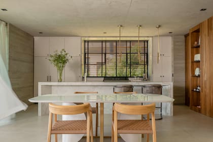 Lámparas colgantes ‘Pepa’ (Fábrica de Luz). Cortina americana de Hunter Douglas (Florencia Franchini). Sobre el margen derecho, el revestimiento de madera (Grupo Forestal) esconde una amplia alacena.