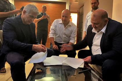 Lapid, Bennett y Abbas, al sellar el acuerdo para formar gobierno, en Ramat Gan