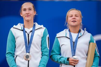 Las atletas neutrales Mirra Andreeva y Diana Shnaider muestran sus medallas de platas tras perder ante las italianas Sara Errani y Jasmine Paolini en la final del dobles femenino de los Juegos Olímpicos de París, el domingo 4 de agosto de 2024.. (AP Foto/Manu Fernändez)