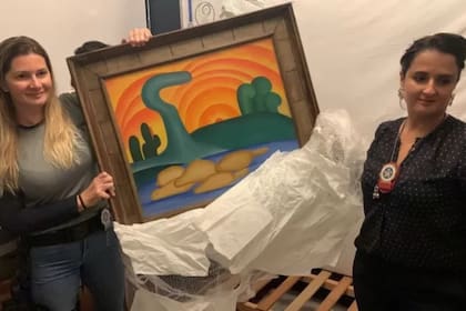 Las autoridades sostienen la pintura de la artista Tarsila do Amaral titulada "Sol Poente" después de que fuera incautada durante una operación policial en Río de Janeiro, Brasil