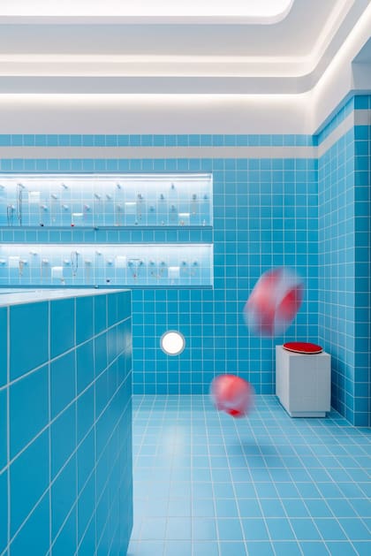 Las baldosas celestes como azulejos y las luces redondas sitúan al cliente dentro de una pileta vacía