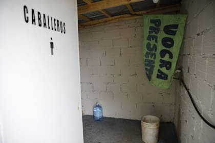 Las banderas de las Uocra en los baños del predio