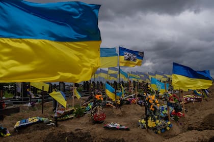 Las banderas ucranianas ondean sobre las tumbas de los soldados caídos en el cementerio de Kharkiv, en el este de Ucrania, el domingo 22 de mayo de 2022.