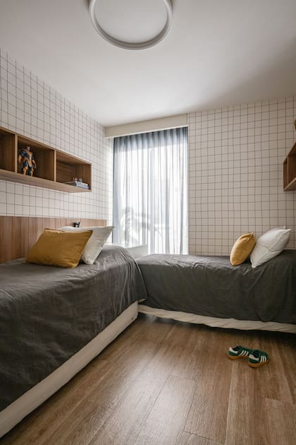 Las camas en L y muebles a medida, de MDF laqueado en blanco y melamina (Estudio Romano Cal), les permitieron ganar espacio de juego.
