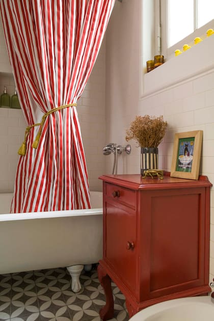 Las cortinas de baño rayadas hacen alusión a la carpa de un circo y el mueblecito de madera se pintó a tono.
