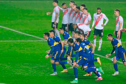 Las dos caras de la definición: los jugadores de Boca corren a abrazar a Carlos Izquierdoz, autor del gol decisivo; los de River lamentan la derrota.