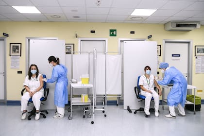 Las enfermeras del Hospital de Cremona, Isabella Palazzini y Clorinda Degano, reciben la vacuna Pfizer-BioNTech Covid-19 en Cremona, Lombardía, el 27 de diciembre de 2020, cuando Italia comienza la vacunación Covid-19