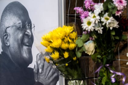 Las flores se colocan junto a una foto del arzobispo anglicano Desmond Tutu en la Catedral de San Jorge en Ciudad del Cabo, Sudáfrica, el domingo 26 de diciembre de 2021.