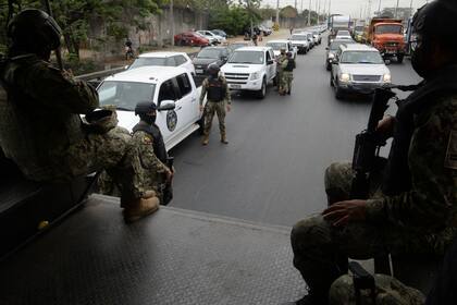 Las fuerzas de seguridad vigilan a un costado de la Penitenciaría del Litoral durante la mañana después de que estallaron nuevos disturbios mortales dentro de esa cárcel en Guayaquil, Ecuador, el sábado 13 de noviembre de 2021. (Foto AP/José Sánchez)