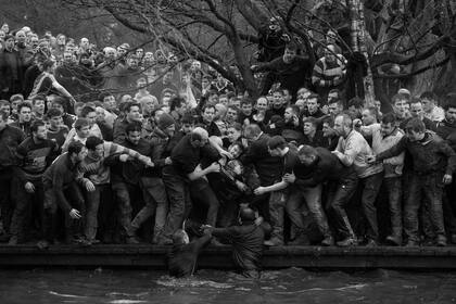 Oliver Scarff ganó el primer premio en la categoría Sport Singles; los equipos oponentes, Upards y Downards, buscan el balón durante el Torneo de fútbol Royal Shrovetide anual en Ashbourne, en el norte de Inglaterra
