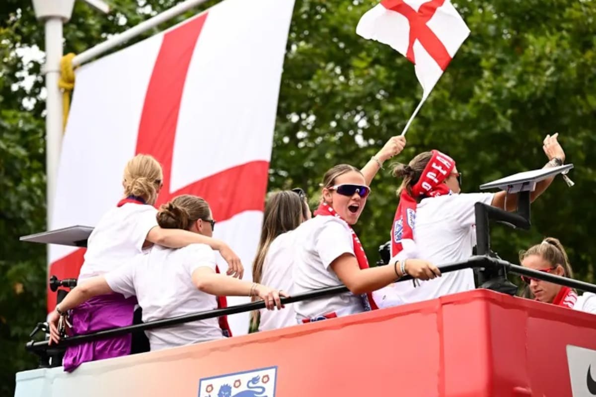 Las jugadoras de fútbol de Inglaterra celebran junto a la bandera de la Cruz de San Jorge durante el desfile de la victoria de las Leonas el 29 de julio.