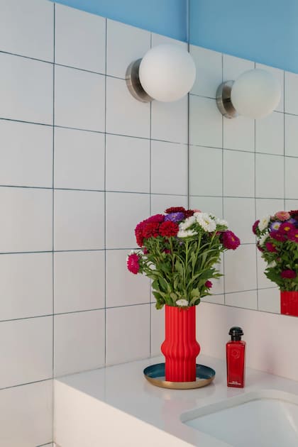 Las juntas celestes combinan con la pared y suman personalidad a un baño de materiales clásicos.