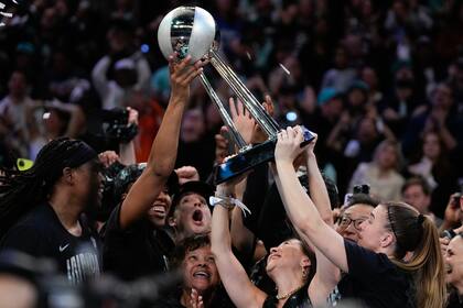 Las Liberty de Nueva York sostienen el trofeo del campeonato después de derrotar a las Lynx de Minnesota en el quinto partido de la serie final de baloncesto de la WNBA, el domingo 20 de octubre de 2024, en Nueva York. (Foto AP/Pamela Smith)