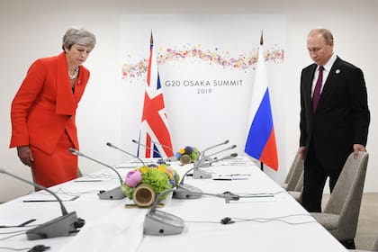 Theresa May, como casi siempre en monocromo, con tailleur de un solo botón en colorado shocking. Y collar de cadena gruesa.