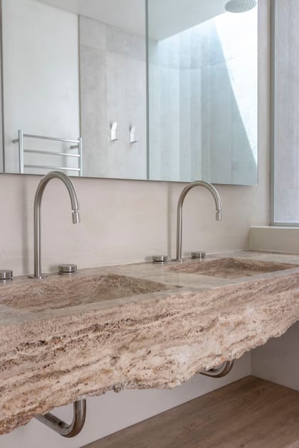 Las mesadas de los baños fueron hechas artesanalmente con piedra natural. Grifería ‘Fabric’ (Peirano).