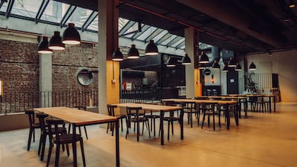 Las mesas comunitarias se disponen junto a los puestos, como un patio de comidas de primer nivel.