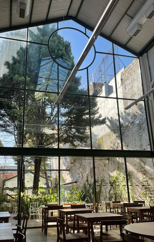 Las mesas se adivinan entre las plantas que empiezan a expandirse en follajes y aromas, a cuatro meses de la apertura en una emblemática propiedad de Palermo.