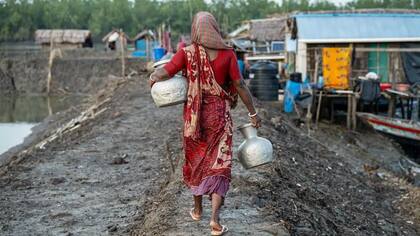 Las mujeres en Bangladesh va a buscar agua potable después de que su pueblo se viera afectado por la intrusión de agua salada
