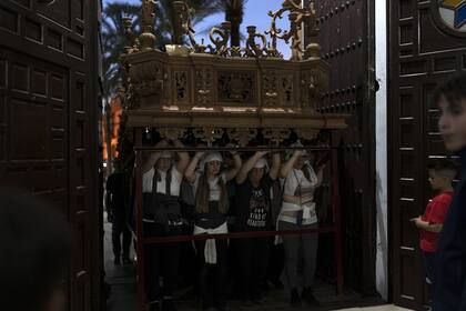 Las mujeres llamadas "los costaleros" actúan y llevan carrozas en el tradicional paso de la hermandad durante la semana previa a la Semana Santa en La Campana, un pueblo a 50 minutos de Sevilla, España