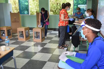 Las mujeres votan durante las elecciones generales en Santo Domingo, el 5 de julio de 2020, en medio de la pandemia de coronavirus