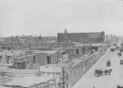 Las obras de construcción del Palacio del Congreso. Sobre la Avenida Rivadavia se observan los frentes tapiados de las edificaciones en el antiguo terreno de Spinetto, utilizados en la construcción del Palacio como cerco de obra. Enero de 1899.