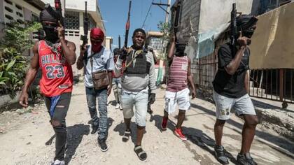 Las pandillas controlan gran parte de la capital de Haití: Jimmy "Barbecue" Cherizier (centro), visto en 2024, lidera una de ellas
