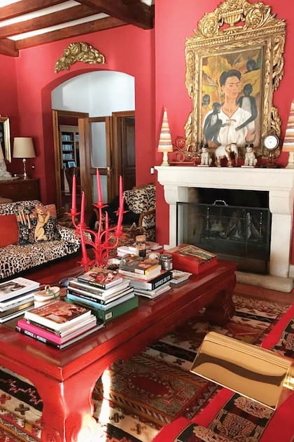 Las paredes del living y del comedor principal están pintadas de colorado. Sobre la chimenea hay un retrato de Frida Kahlo.