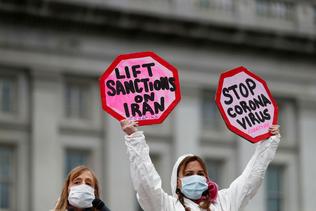 Las personas asisten a una protesta contra el papel que juegan las sanciones estadounidenses en Irán y la exacerbación de la enfermedad por coronavirus