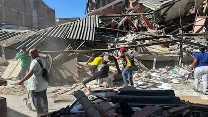 Las personas buscan familiares en las viviendas derrumbadas