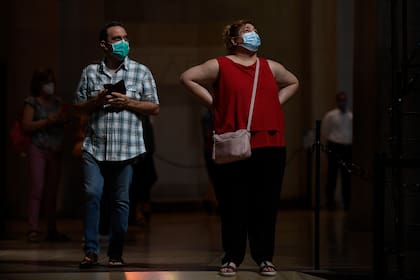 Las personas con máscaras faciales visitan la basílica de la Sagrada Familia en Barcelona el 4 de julio de 2020, que reabrió con un homenaje a los trabajadores de la salud