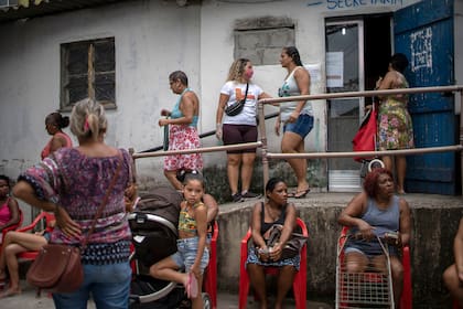 Las personas esperan recibir donaciones de alimentos básicos distribuidos por una ONG a las personas que sufren durante el nuevo brote de coronavirus en la favela Cidade de Deus (Ciudad de Dios) en Río de Janeiro, Brasil, el 7 de abril de 2020
