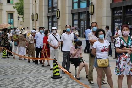 Las personas hacen fila para someterse a pruebas de coronavirus en un centro improvisado en Dalian, en la provincia de Liaoning, noreste de China, el 27 de julio de 2020