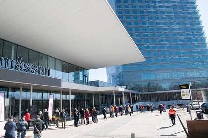 Las personas hacen fila para vacunarse contra el Covid-19 fuera del centro de exposiciones Stockhomsmassan convertido en un centro de vacunación en Estocolmo