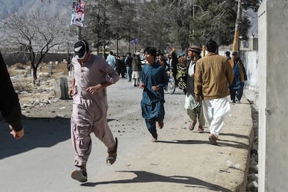Las personas huyen de un centro de votación después de un ataque con granadas de mano en las proximidades de la zona de Sariab, durante las elecciones nacionales de Pakistán, en Quetta.  (Banaras KHAN / AFP)