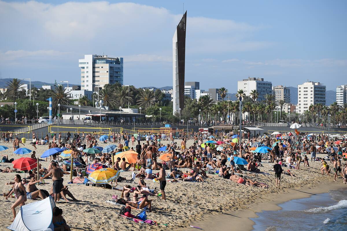 Las personas nadan y toman el sol en la playa del Bogatell en Barcelona, ??una de las varias de la ciudad que se cerró el 19 de julio de 2020 debido a la capacidad permitida