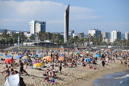 Las personas nadan y toman el sol en la playa del Bogatell en Barcelona, ??una de las varias de la ciudad que se cerró el 19 de julio de 2020 debido a la capacidad permitida