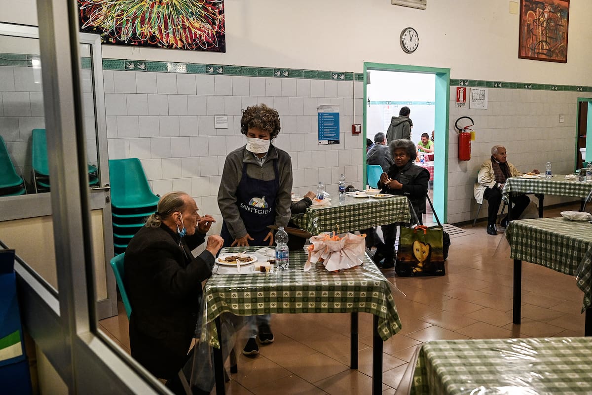 Las personas necesitadas almuerzan en la cantina de la comunidad católica laica de SantEgidio dedicada al servicio social en Roma, el 13 de abril de 2020