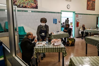 Las personas necesitadas almuerzan en la cantina de la comunidad católica laica de SantEgidio dedicada al servicio social en Roma, el 13 de abril de 2020