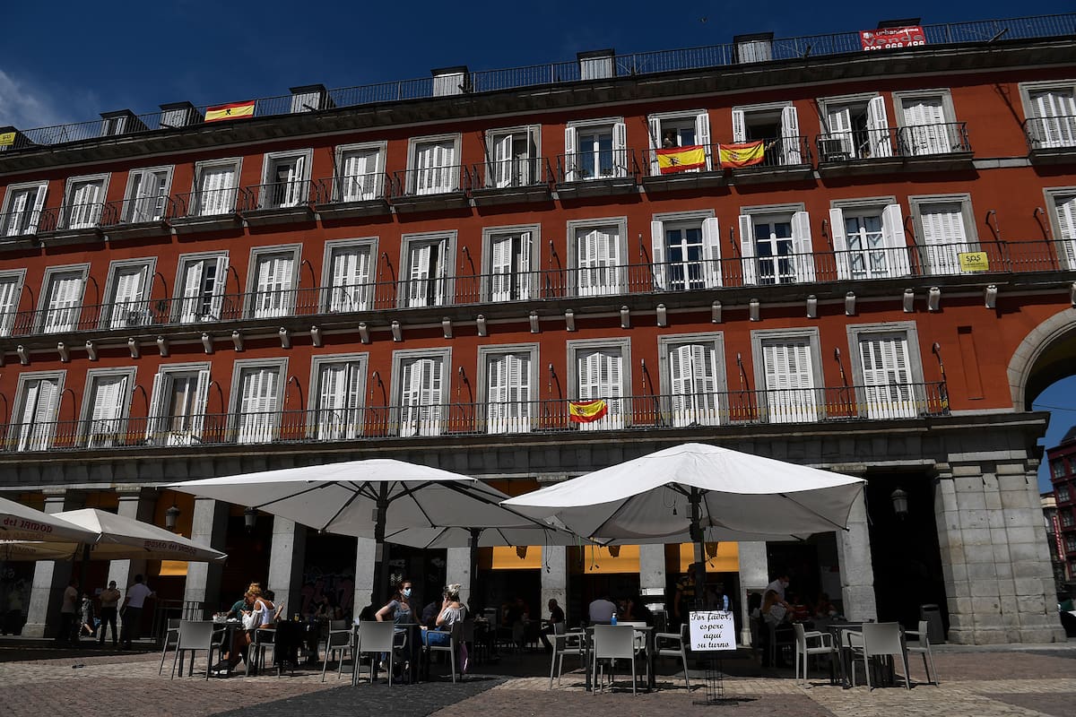 Las personas se sientan en un bar en la Plaza Mayor de Madrid el 25 de mayo de 2020, luego de que las medidas de bloqueo del coronavirus finalmente se flexibilizaron para las personas en Madrid y Barcelona