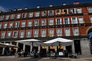 Las personas se sientan en un bar en la Plaza Mayor de Madrid el 25 de mayo de 2020, luego de que las medidas de bloqueo del coronavirus finalmente se flexibilizaron para las personas en Madrid y Barcelona