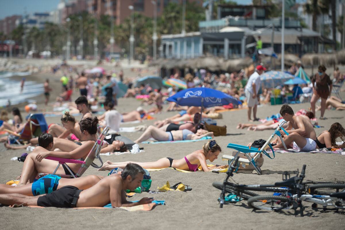 Las personas toman el sol en la playa de La Misericordia en Málaga el 7 de junio de 2020, mientras se alivian las medidas de bloqueo durante la pandemia de coronavirus