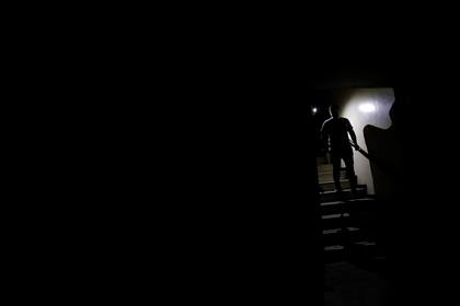 Las personas usan la luz de los teléfonos mientras bajan una escalera de un edificio durante un apagón en Caracas, Venezuela, el 7 de marzo de 2019.