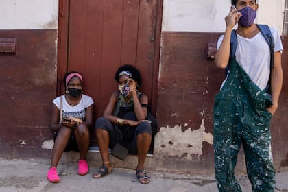 Las personas usan máscaras durante la pandemia de COVID-19 afuera de una tienda de comestibles donde esperan que abra en La Habana, Cuba, el martes 12 de octubre de 2021.
(AP Foto/Ramón Espinosa)