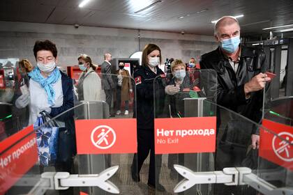 Las personas usan máscaras faciales en la estación de metro Savyolovskaya en el primer día de uso obligatorio de máscaras y guantes en el transporte público de Moscú, el 12 de mayo de 2020, en medio de la pandemia de coronavirus