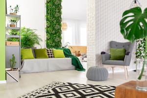 Las plantas naturales y un jardín vertical en un living dan sensación de frescura y aire libre, también la deco que acompaña en tonos verdes, blancos y grises