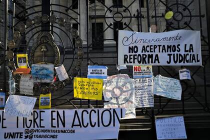 Un collage de carteles contra la reforma judicial en las rejas del Congreso