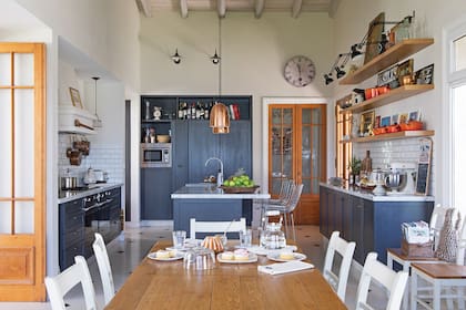 Muebles enchapados en madera y laqueados en gris azulado (diseño y fabricación de Flora Oliva). Las puertas de madera y vidrio repartido son de demolición (El Umbral de Piñeyro).